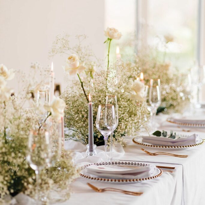 Tablescape of gold cutlery and glassware setup.